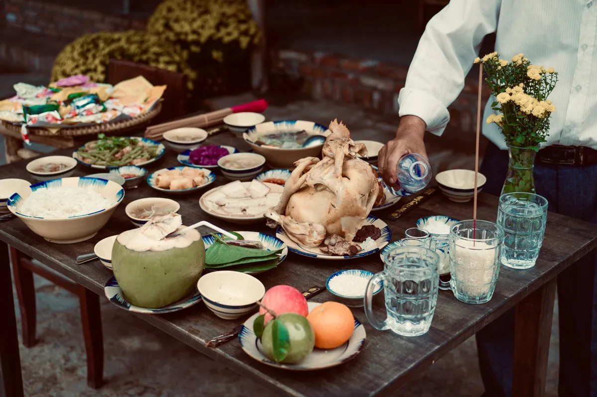 Dog bowl with a measured portion of boiled chicken and rice, surrounded by a glass of water and a small dish of electrolyte solution