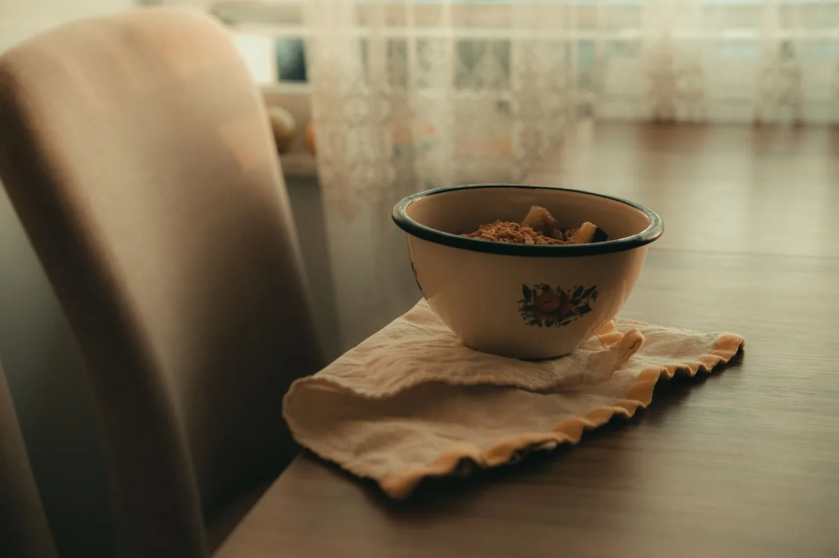 Bright kitchen scene with a dog bowl filled with high‑quality kibble and a small dish of fish oil supplement