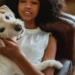 Middle-aged mixed-breed dog lying on a couch, looking tired with a concerned owner checking its gums