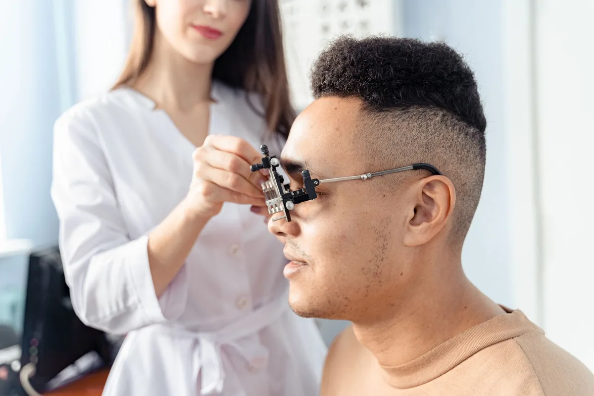 Veterinarian gently examining a dog's eye with a slit lamp, showing careful focus on the retina